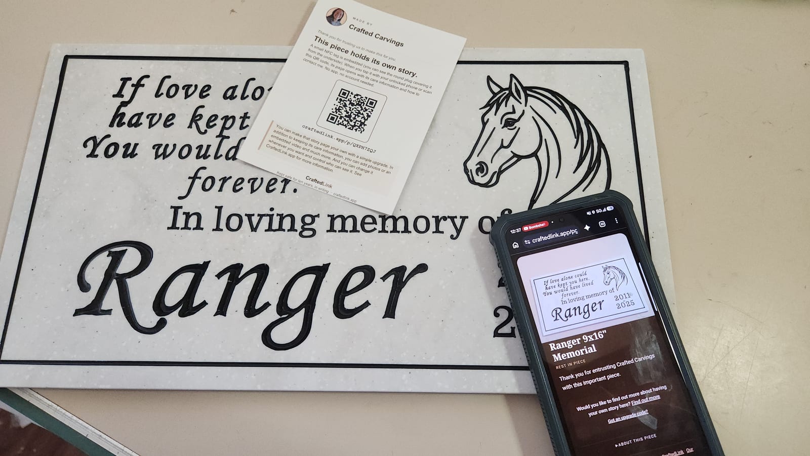 A memorial sign, the insert card that ships with it, and a phone showing the page a tap opens